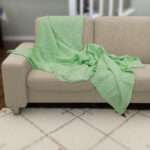 Pure cotton, box waffle throw in creamy pistachio color on beige sofa