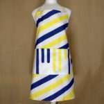 Yellow piano apron on mannequin from hem and tassel