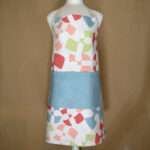 flock and flutter design apron in slate on mannequin from hem and tassel