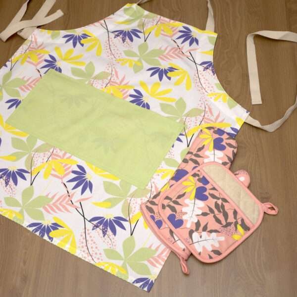 pollen up design apron in mint flat with blush oven mitt and pot holderfrom hem and tassel