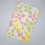 Celebration design tea towel in blush flat folded from hem and tassel