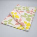Celebration design tea towel in blush folded from hem and tassel