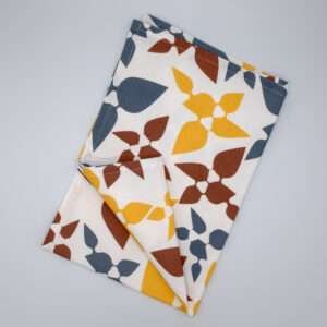 Celebration design tea towel in clay flat folded from hem and tassel