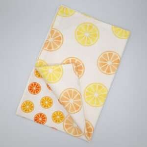 Faded orange design tea towel flat folded from hem and tassel