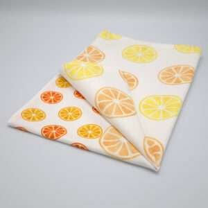 Faded orange design tea towel folded from hem and tassel