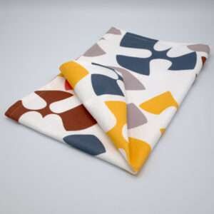 Flock and Flutter design tea towel in grey folded from hem and tassel