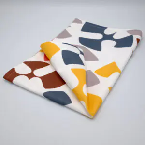 Flock and Flutter design tea towel in grey folded from hem and tassel