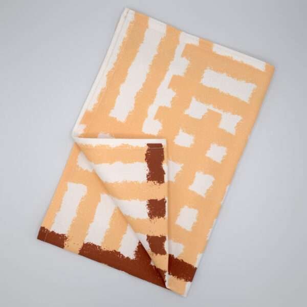 Jute impossible checked design tea towel flat folded in buff from hem and tassel