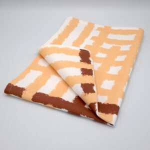 Jute impossible checked design tea towel folded in buff from hem and tassel