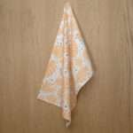 Monster Ah design hanging tea towel in buff and turf from hem and tassel