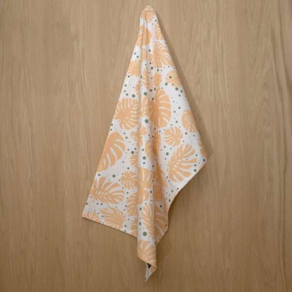 Monster Ah design hanging tea towel in buff and turf from hem and tassel