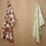 Monster Ah design two hanging tea towels from hem and tassel