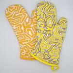 Squiggles maze design mitts in orange and yellow from hem and tassel