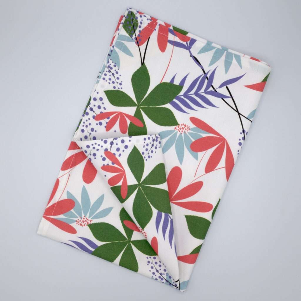 pollen up design tea towel in pink flat folded from hem and tassel