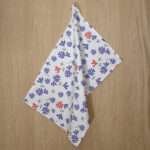 shy dragonfly hiding design hanging tea towel in purple and pink from hem and tassel
