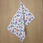 shy dragonfly hiding design hanging tea towel in purple and pink from hem and tassel