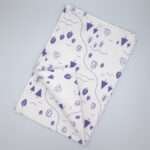 tiny countryside design tea towel in purple flat folded from hem and tassel