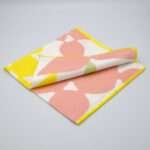 Celebration design dinner napkin in blush folded from hem and tassel