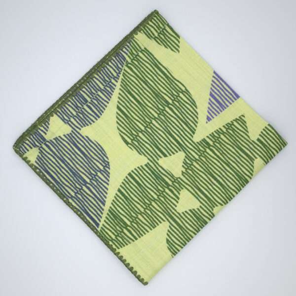 Celebration design dinner napkin in green flat folded from hem and tassel