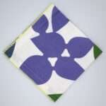 Celebration design dinner napkin in purple flat folded from hem and tassel