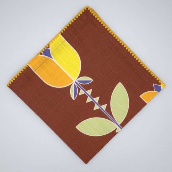 Lip TuLip design dinner napkin in orange flat folded from hem and tassel