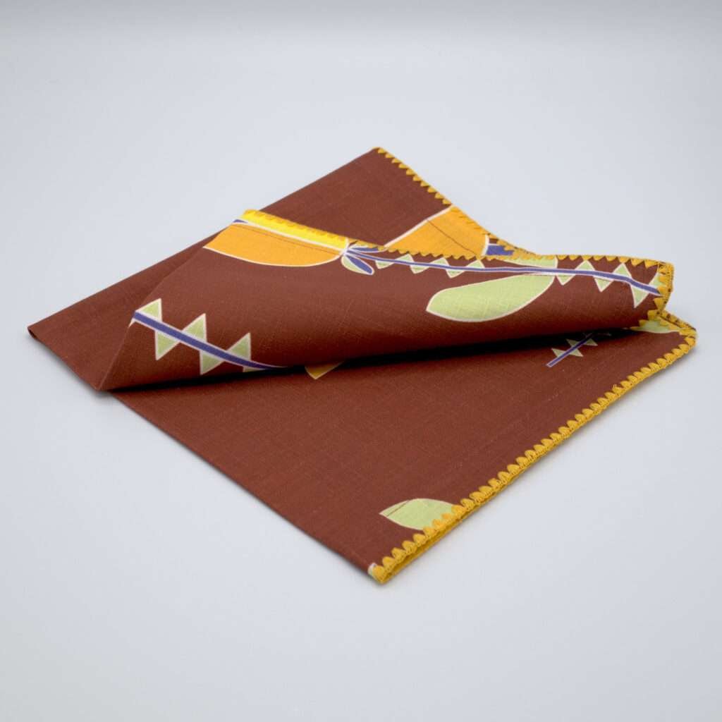 Lip TuLip design dinner napkin in orange folded from hem and tassel