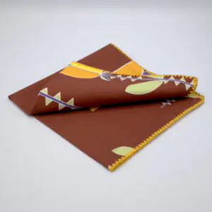 Lip TuLip design dinner napkin in orange folded from hem and tassel