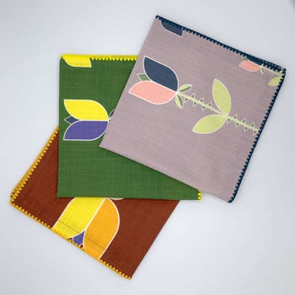 Lip TuLip design dinner napkins in three colors fanned from hem and tassel