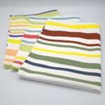 Not straight design set of three broad tea towels folded out from hem and tassel