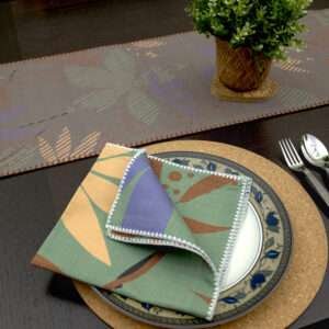 Pollen up design Dinner Napkin in purple with dark table runner looking down LS from hem and tassel