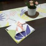 Pollen up design Dinner Napkin in yellow with pastels table runner looking down LS from hem and tassel