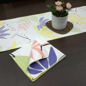 Pollen up design Dinner Napkin in yellow with pastels table runner looking down LS from hem and tassel