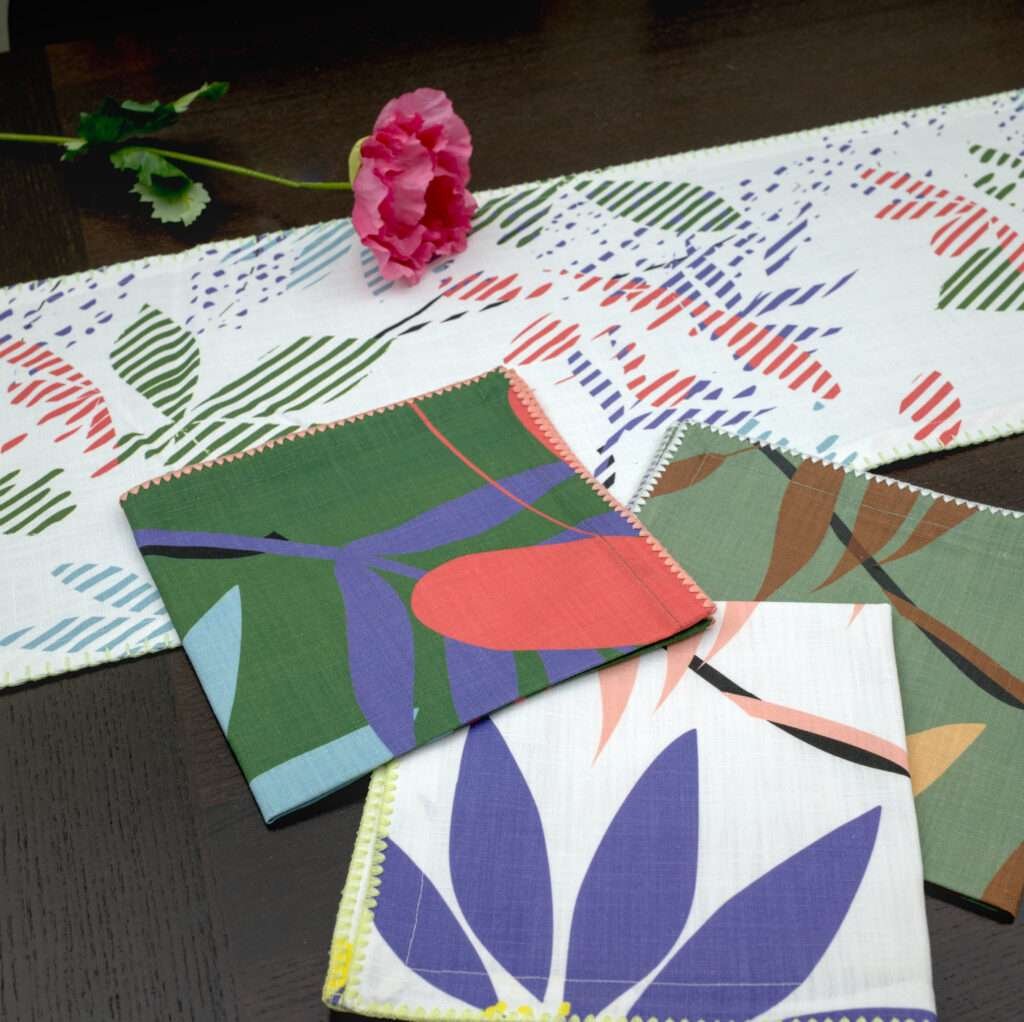 Pollen up design Dinner Napkins in tnree colors with blue table runner LS from hem and tassel