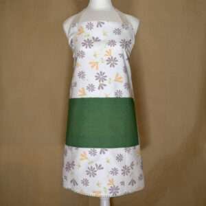 Shy dragonfly design apron with buff and grey flowers on mannequin from hem and tassel