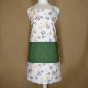 Shy dragonfly design apron with buff and grey flowers on mannequin from hem and tassel