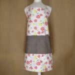 Shy dragonfly design apron with pink flowers on mannequin from hem and tassel