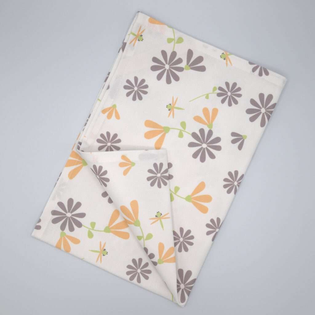 Shy dragonfly flowers design tea towel in grey and buff flat folded from hem and tassel