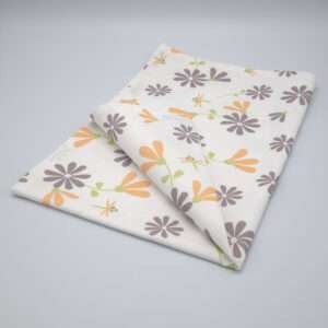 Shy dragonfly flowers design tea towel in grey and buff folded from hem and tassel