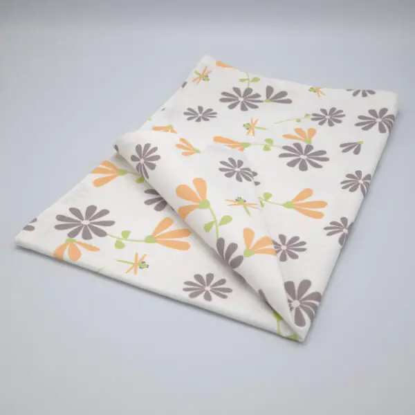 Shy dragonfly flowers design tea towel in grey and buff folded from hem and tassel