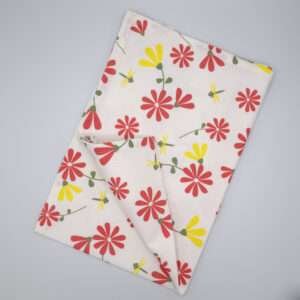 Shy dragonfly design tea towel in pink and yellow flat folded from hem and tassel