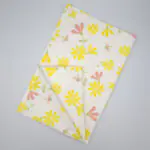 Shy dragonfly design tea towel in yellow and blush flat folded from hem and tassel
