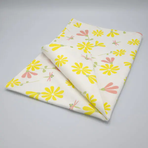 Shy dragonfly design tea towel in yellow and blush folded from hem and tassel