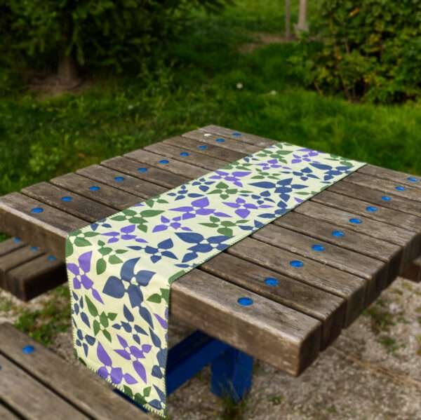 Table runner of celebration design in mint on picnic table by Hem And Tassel