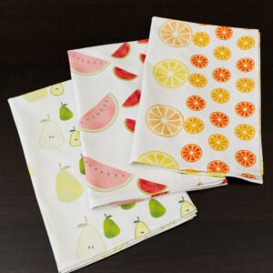 Three folded towels of faded fruit design