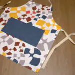 flock and flutter design apron in grey flat from hem and tassel
