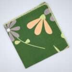 shy dragonfly design dinner napkin in green flat folded from hem and tassel