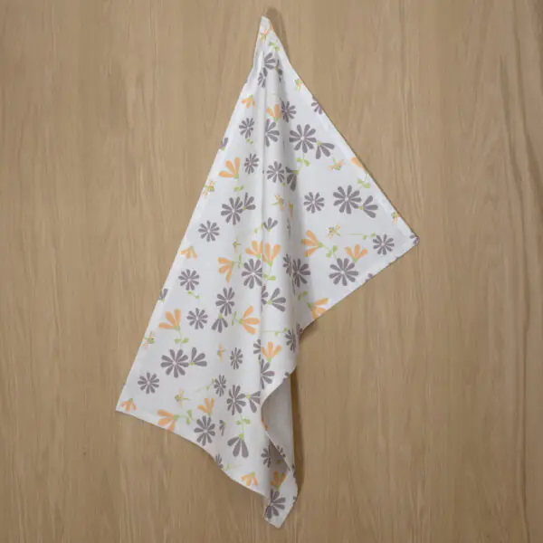 shy dragonfly flowers design hanging tea towel in buff annd grey from hem and tassel