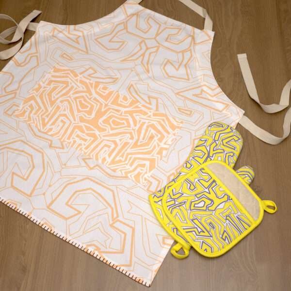 squiggles symmetric design apron in buff with yellow oven mitt and pot holder flat from hem and tassel