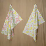 two hanging tea towels in blush and yellow from hem and tassel
