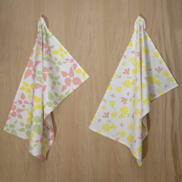 two hanging tea towels in blush and yellow from hem and tassel
